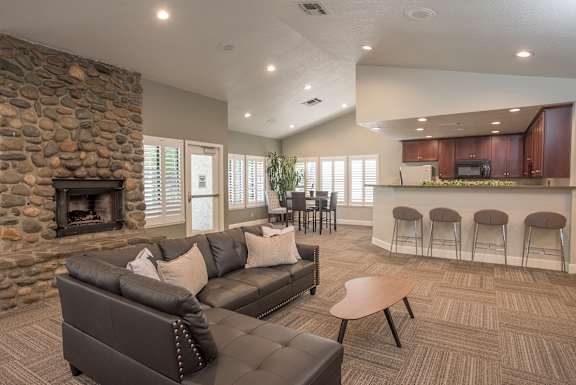 A clubhouse with a stone fireplace and a couch at Zinfandel Village Apartments, California, 95670
