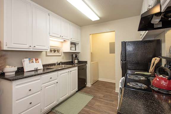 A kitchen with white cabinets and a black stove top at Zinfandel Village Apartments, California, 95670