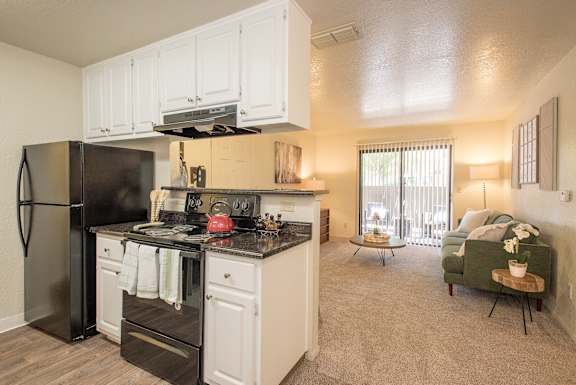A kitchen with black appliances and white cabinets at Zinfandel Village Apartments, California, 95670