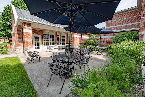 A patio with a table and chairs under an umbrella.