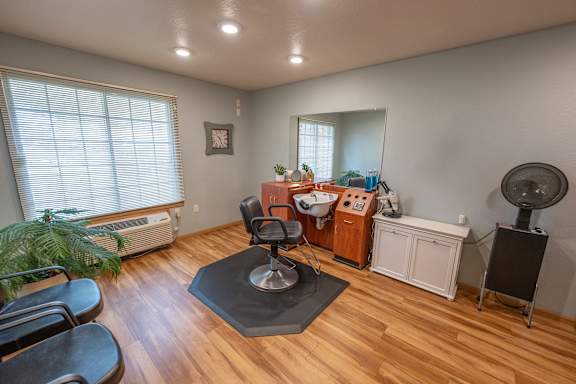 A room with a wooden floor and a table with a mirror on it.