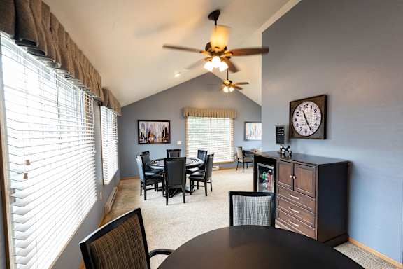 A dining room with a table and chairs.