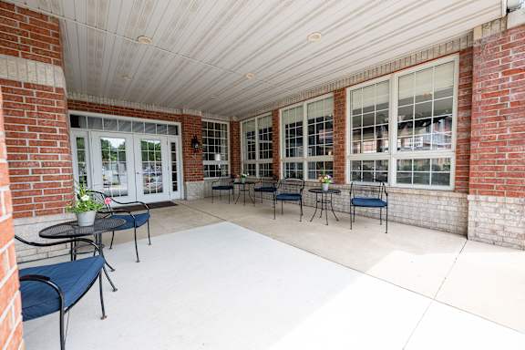 A patio with a table and chairs is covered by a white roof.