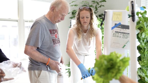 A man and a woman are standing in front of a fridge.
