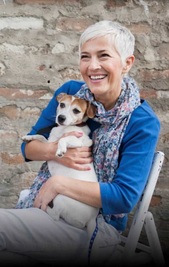 a woman sitting in a chair holding a dog