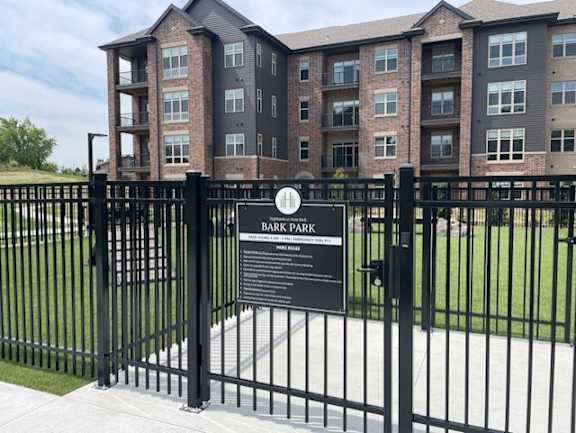 A sign in front of a building entrance reads Bark Park.