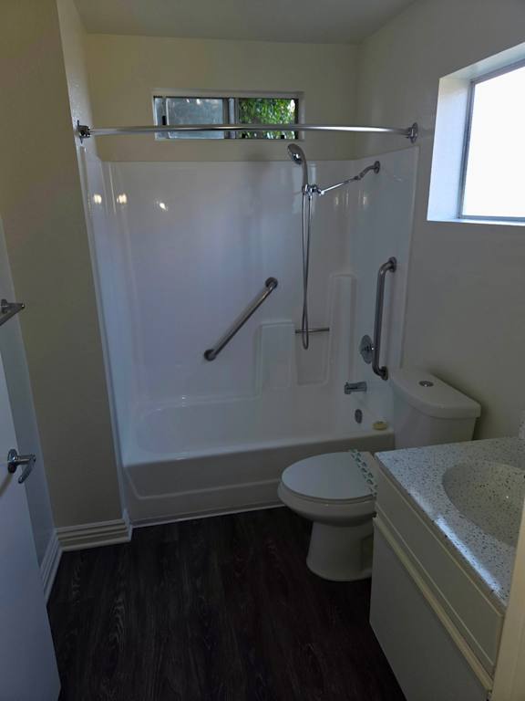 A white bathroom with a toilet, sink, and shower.