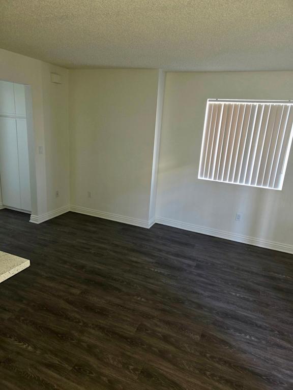 A room with a window and a wooden floor.