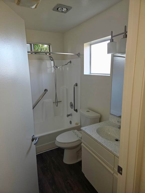 A white toilet is in a bathroom with a sink and a shower.