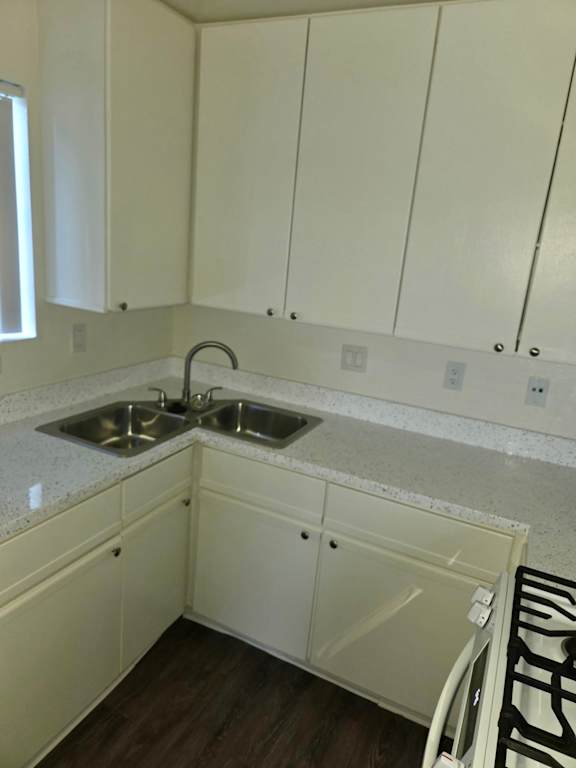 A kitchen with white cabinets and a sink.