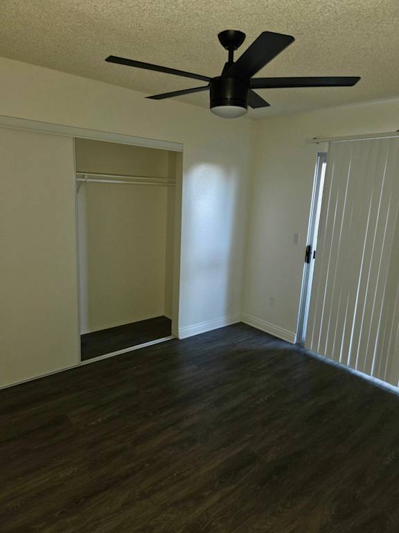 A room with a ceiling fan and sliding door.