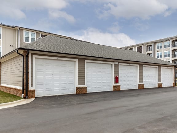 a garage with white doors and a building behind it