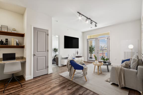 a living room with a couch and a desk and a tv