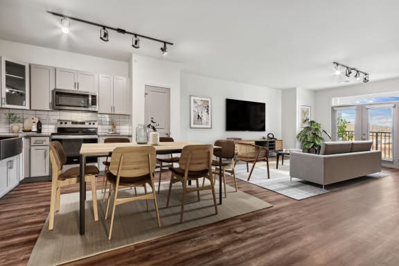 an open living room with a dining room table and chairs and a kitchen