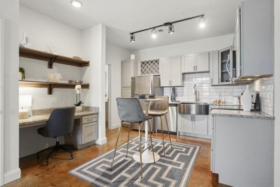 a kitchen and living room with a bar and a dining table