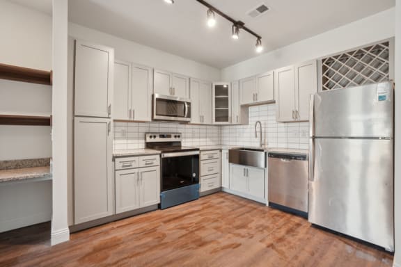 a kitchen with stainless steel appliances and white cabinets