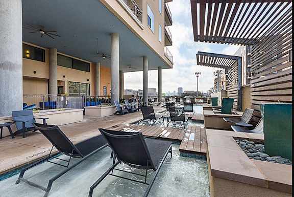 a patio with a pool and chairs and tables