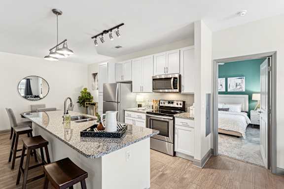 A modern kitchen with a granite countertop and stainless steel appliances.