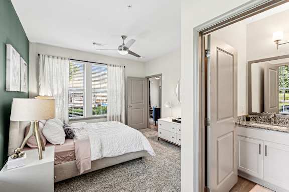 A bedroom with a bed, dresser, and mirror.
