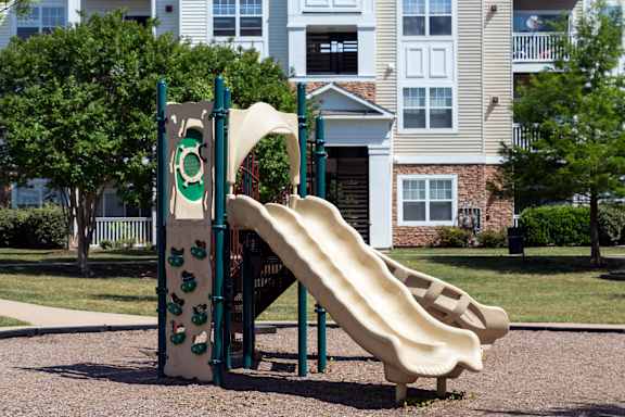 a slide on a playground in front of a house
