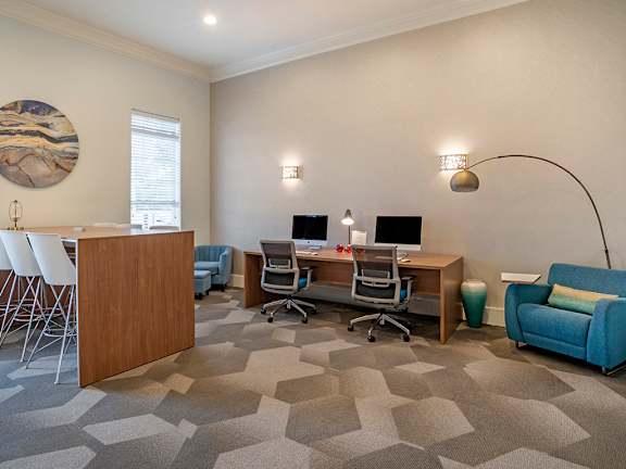 a room with a desk with two computers and a chair