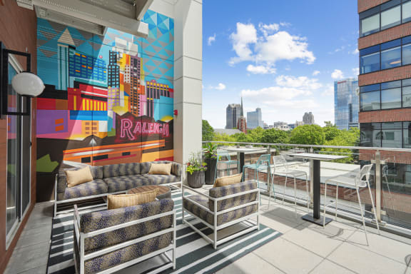 a terrace with couches and a table and a mural on the wall