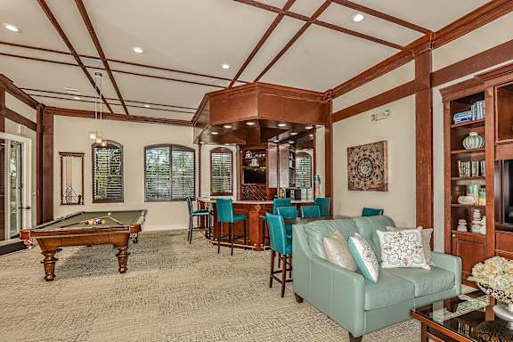 A living room with a pool table and a couch.