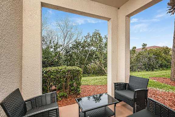 A patio with a table and chairs overlooking a garden.