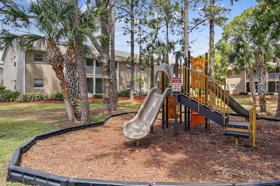 A playground with a slide and a no-slide sign.