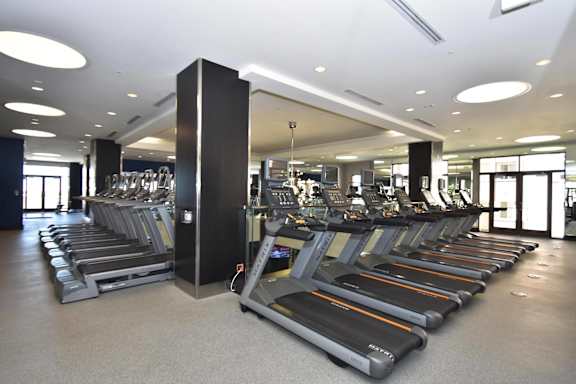 A gym with treadmills and a large mirror.