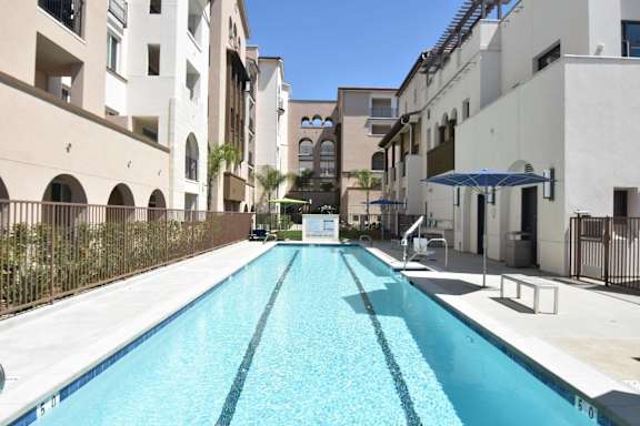 A long rectangular pool in a courtyard surrounded by buildings.