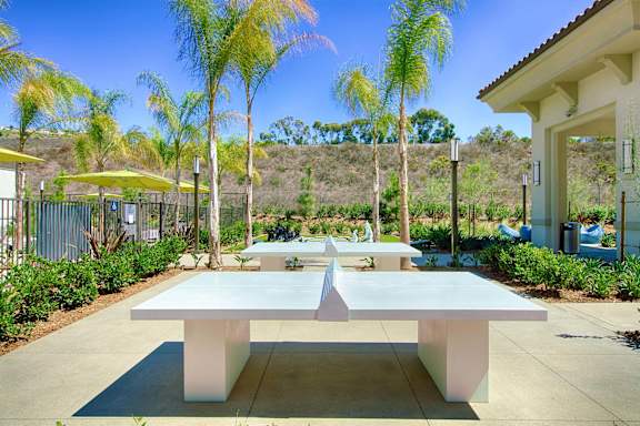 A white table is in the middle of a patio.