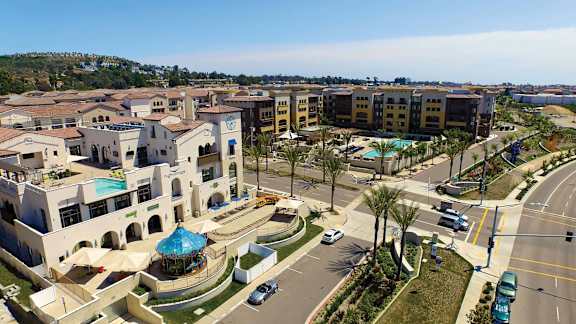A view of a resort with a pool and palm trees.
