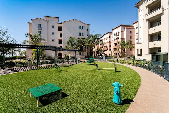 A green fire hydrant sits on a green lawn.