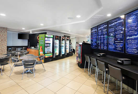 A restaurant with a counter and chairs.