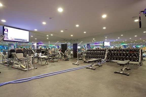 Spacious fitness center with weight equipment and screens at Torrey Gardens Apartments, San Diego, CA
