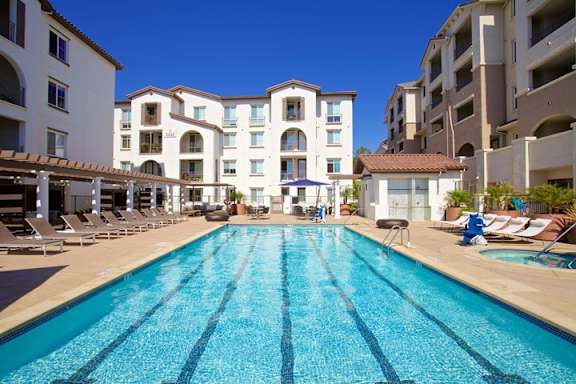 Resort style swimming pool with lane markings and lounge chairs at Torrey Gardens Apartments, California