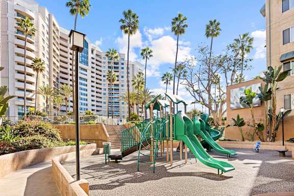 Playground area with slides and palm trees at Costa Verde Village Apartments, California