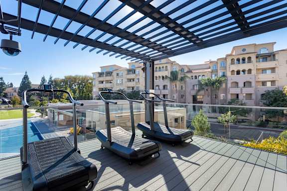 Rooftop fitness deck with curved treadmills and pergola at 360 Luxury Apartments, San Diego, California