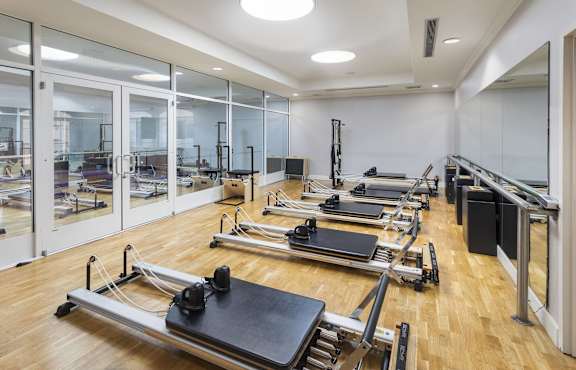 A pilates room with reformers and mirrors.