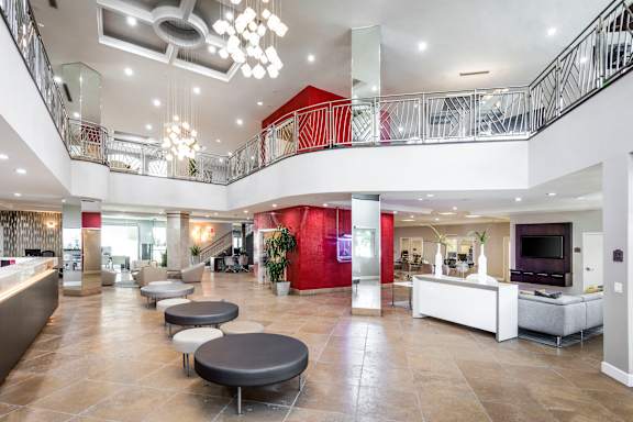A spacious atrium with a staircase and a red accent wall.