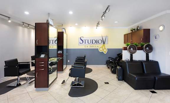 A hair salon with black chairs and a sign that says "Studio La Jolla".