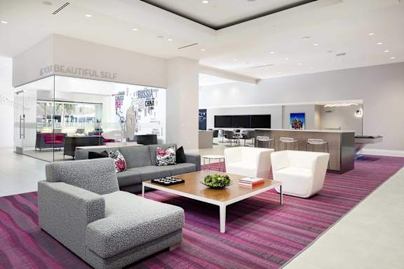 Bright lobby area with modern seating and striped carpet at Metropolis Apartments, IRVINE, CA