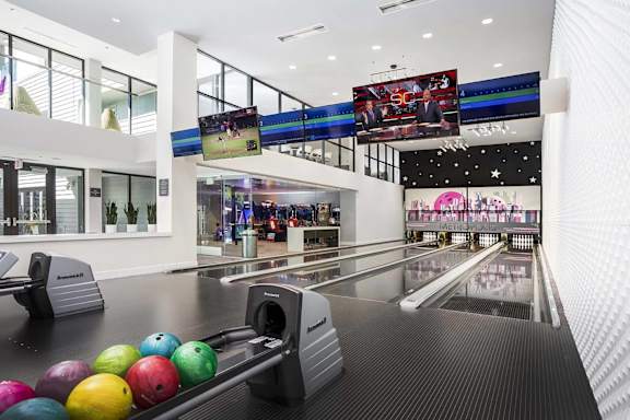 Bowling alley with colorful balls and multiple lanes at Metropolis Apartments, IRVINE, 92614