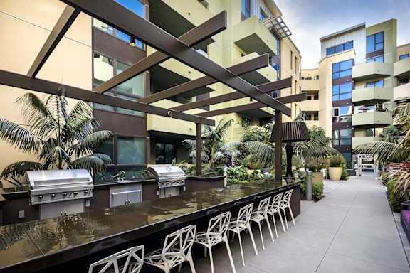 Outdoor kitchen and dining area with bbq grills at Metropolis Apartments, IRVINE, California