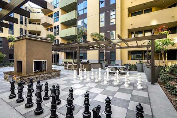 Outdoor chess board with oversized pieces and courtyard seating at Metropolis Apartments, IRVINE