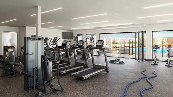 Fitness center with cardio equipment and pool view at Garden at 3Roots Apartments, San Diego, CA