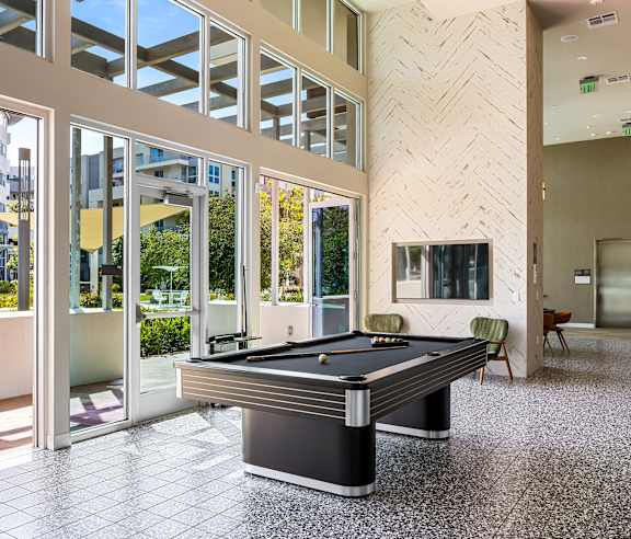 Recreation room with pool table and herringbone accent wall at Elements Apartments, California, 92612