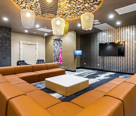 Resident lounge with pendant lights and sectional seating at Elements Apartments, California, 92612