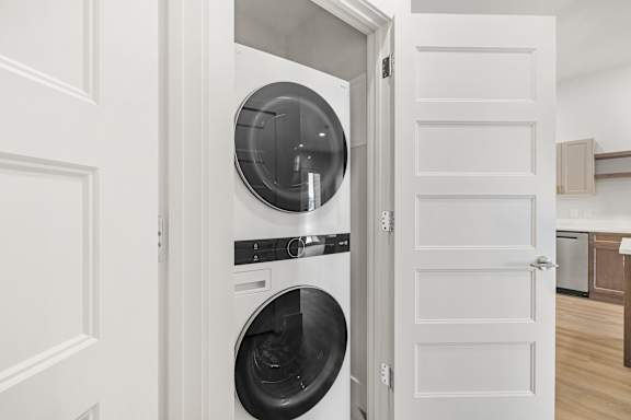 A white door opens to a modern kitchen.